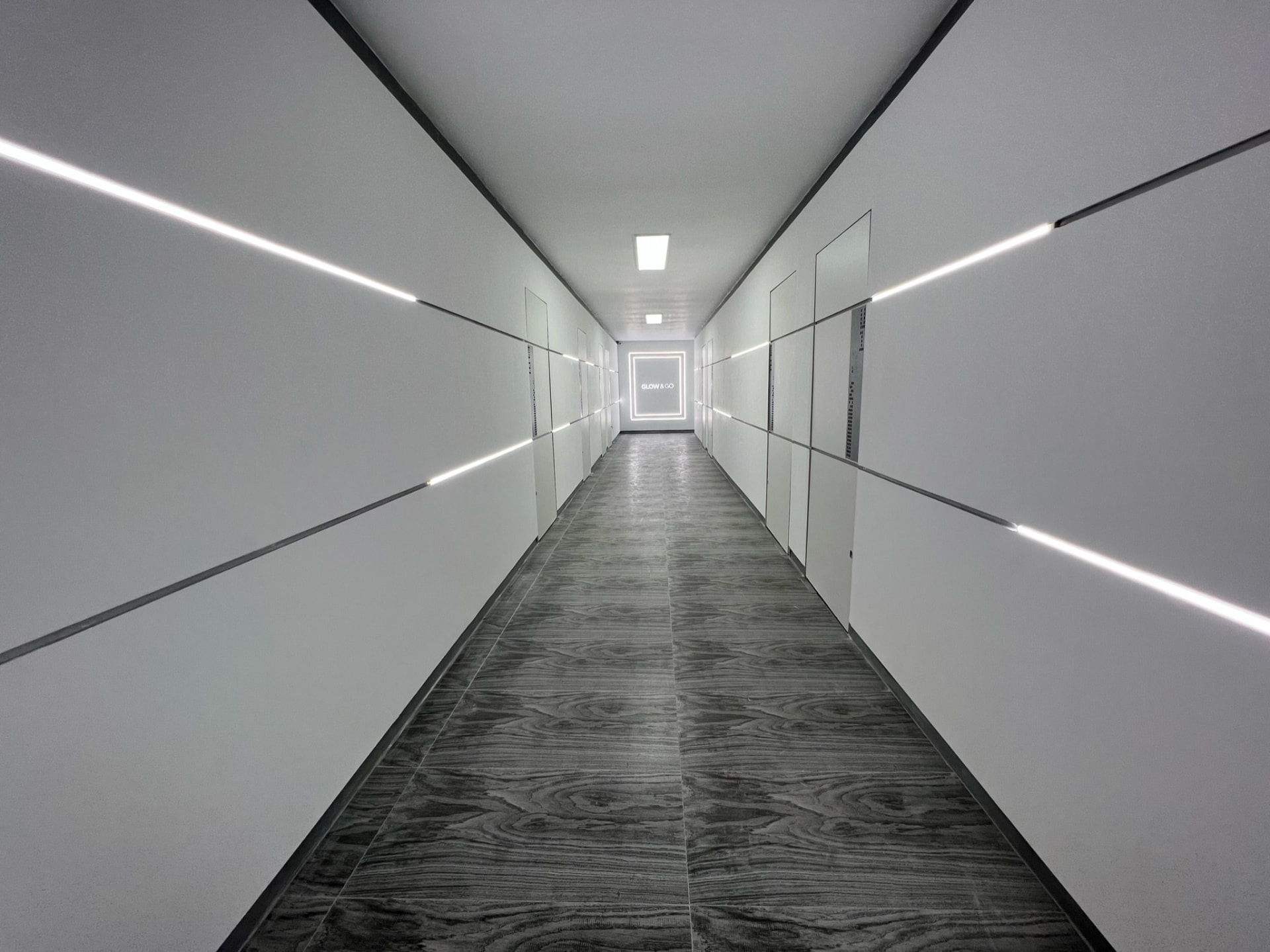 Glow & Go clinic corridor with white walls and linear lighting